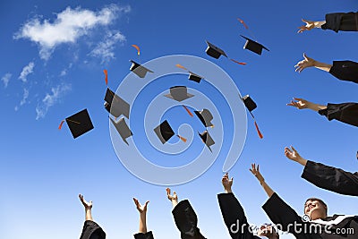 Students throwing graduation hats Stock Photo