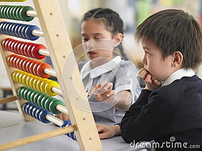 Students Using Abacus In Classroom Stock Photo