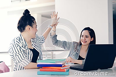 Students women teamwork high five together working study online or homework success project with laptop computer and meeting in un Stock Photo