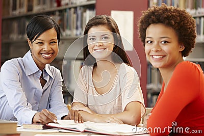 2 Students working in library with teacher Stock Photo