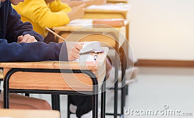 students writing test exam on paper for Admissions in high school with uniform student in School classroom of Thailand exam Stock Photo