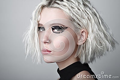 Studio beauty portrait of young woman with black graphic makeup. Stock Photo