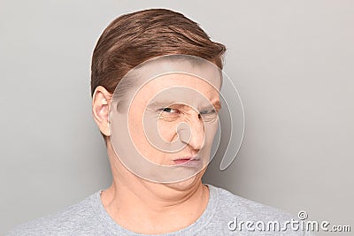 Portrait of funny man grimacing from disgust and squeamishness Stock Photo