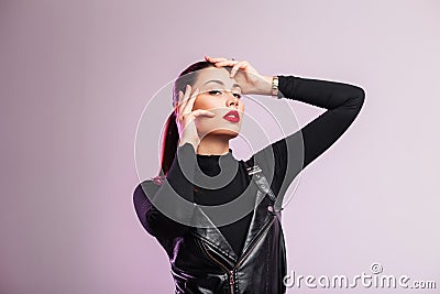 Studio fashion portrait chic beautiful young woman with sexy red lips with brown hair in black fashionable leather clothes on a Stock Photo