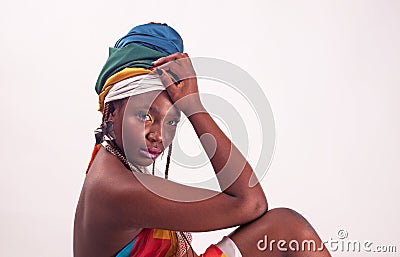 Studio fashion portrait of young African woman in summer dress and ethnic head wrap, white background Stock Photo