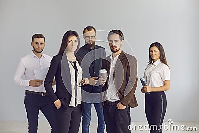 Group portrait of serious young business people standing in studio looking at camera Stock Photo