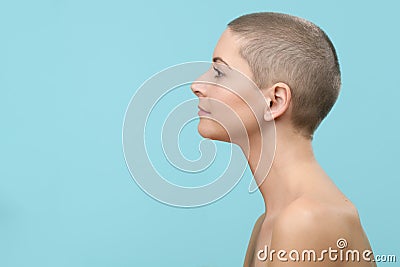 Studio headshot portrait of a beautiful young caucasian woman with shaved head against pastel blue background. Cancer survivor. Stock Photo
