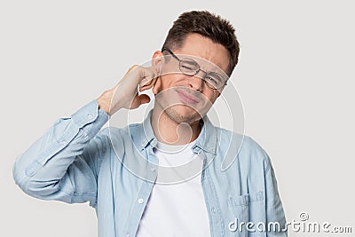 Studio headshot young man suffers from earache or noise Stock Photo