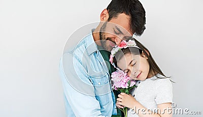 Studio image of handsome father hold embraces his cute daughter and giving her a pink flower. Loving daddy and his little girl Stock Photo