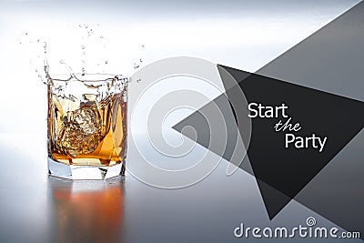 Studio isolated splashing whiskey over white background. Two ice cubes fall into a glass of whiskey. Stock Photo