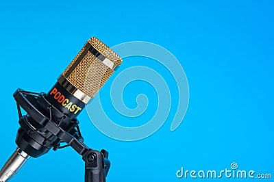 Studio microphone for recording podcasts, songs, and radio programs on a blue background with a place for inscription Stock Photo