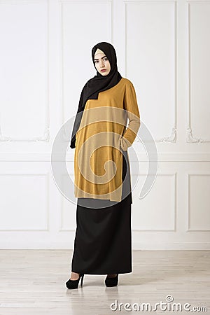 Studio photo of a beautiful young woman eastern type full-length, on a light background, dressed in the Muslim style Stock Photo