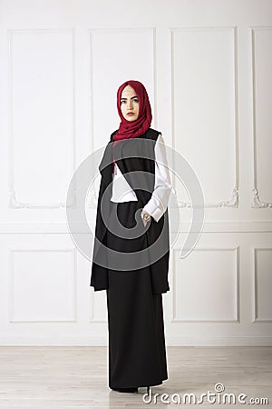 Studio photo of an oriental woman in a modern Muslim clothing, a scarf and a gold watch hand well Stock Photo