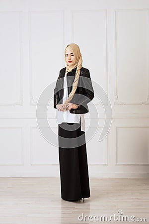 Studio photo of a young woman eastern type of clothing that combines modern and Muslim style, and a beautiful headdress Stock Photo