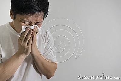 Studio picture from a young man with handkerchief. Sick guy has runny nose Stock Photo