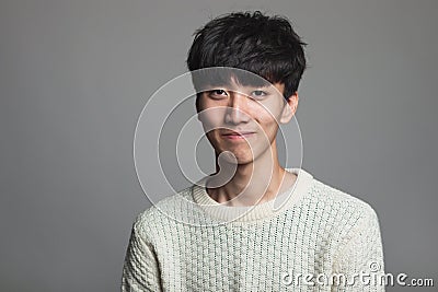 A studio portrait of an Asian man looking ahead with a confident smile Stock Photo