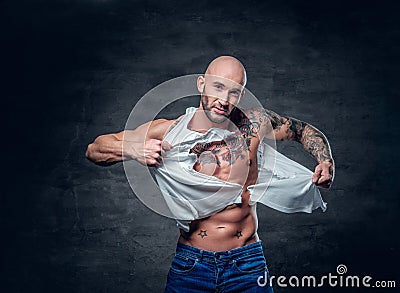 Studio portrait of athletic male with a tattoo on his chest ripp Stock Photo