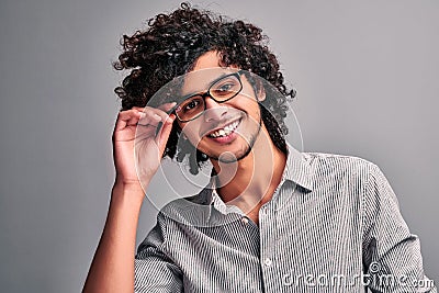 Arabian guy with curly hair on gray isolated background Stock Photo