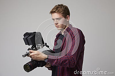 Studio Portrait Of Male Videographer With Film Camera Stock Photo