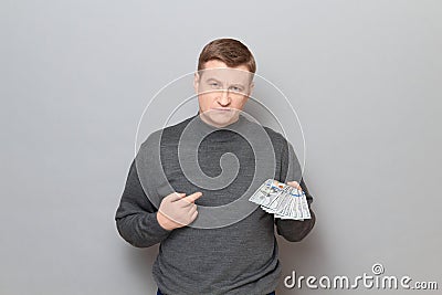 Portrait of proud confident mature man pointing at money Stock Photo