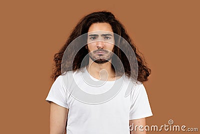 Studio Portrait Of Sad Arabic Guy With Long Curly Hair Stock Photo