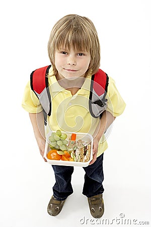 Studio Portrait of Smiling Boy Holding Lunchbox Stock Photo