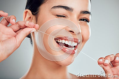 Studio portrait of a smiling mixed race young woman with glowing skin posing against grey copyspace background while Stock Photo