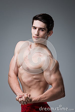 Studio portrait of a young brunette caucasian man on gray background posing. Puberty theme, problem skin, teen acne Stock Photo