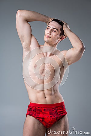 Studio portrait of a young brunette caucasian man on gray background posing. Puberty theme, problem skin, teen acne Stock Photo