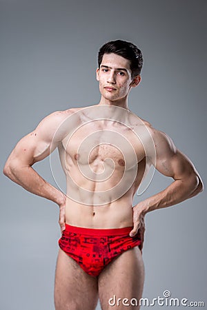 Studio portrait of a young brunette caucasian man on gray background posing. Puberty theme, problem skin, teen acne Stock Photo