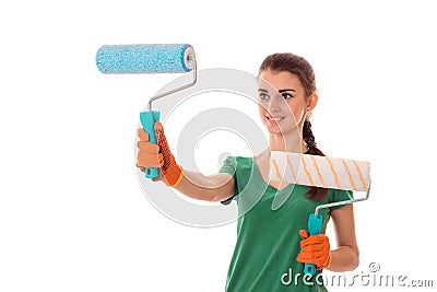 Studio portrait of young happy brunette girl in uniform makes renavation with paint roller in hands smiling isolated on Stock Photo