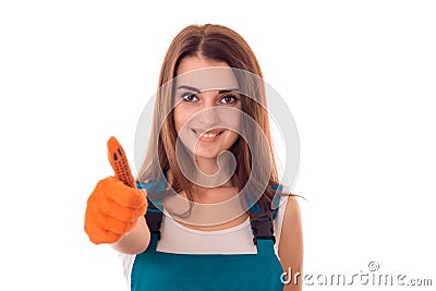 Studio portrait of young happy girl in uniform makes renavation and showing thumbs up isolated on white background Stock Photo