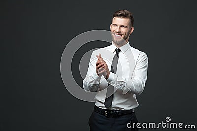 Studio portrait of young happy handsome businessman claping hand Stock Photo