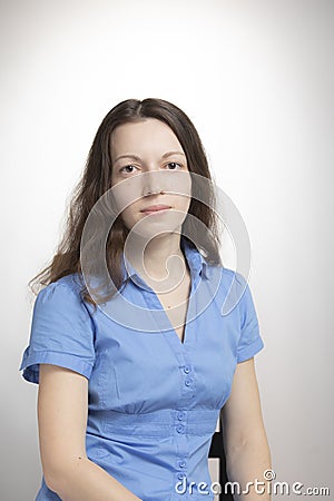 studio portrait of young pretty long-haired woman on white. She seems calm and serious looking at camera. People, emotions, Stock Photo