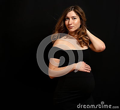 Studio shoot of beautiful gorgeous pregnant woman on black background Stock Photo