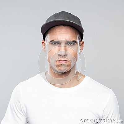 Portrait of angry young man in baseball cap Stock Photo