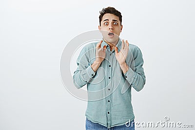 Studio shot of anxious troubled miserable guy in casual outfit, raising palms and staring with fright at camera, being Stock Photo