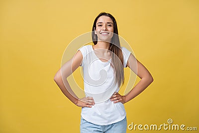 Studio shot of attractive self confident young female in great mood feeling happy, holding hands on her slender waist Stock Photo