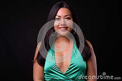 Beautiful overweight Asian woman wearing silky green dress Stock Photo