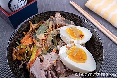 Studio shot of black bowl of ramen noodles with boiled eggs, veggies and turkey meet, ready to be poured with boiling Stock Photo
