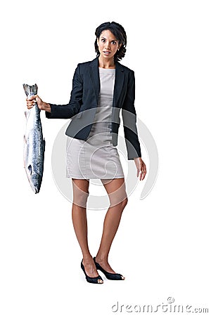 Somethings fishy here.... - Suspicious business deals. Studio shot of a businesswoman holding a dead fish against a Stock Photo