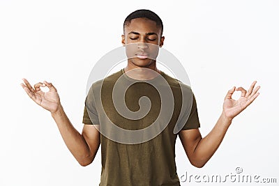 Studio shot of calm and peaceful young african american sportsman standing in lotus pose searching nirvana and patience Stock Photo