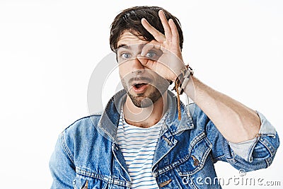 Studio shot of charismatic and joyful handsome european man with blue eyes showing zero or null with circle over eye and Stock Photo