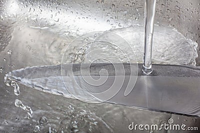 cleaning a sharp knife with water Stock Photo