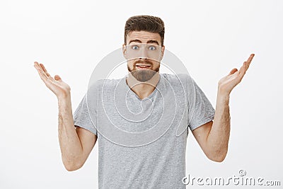 Studio shot of clueless unaware handsome bearded man shrugging with raised hands and eyebrows making silly clueless Stock Photo