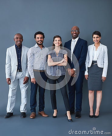 We here for the opportunity. Studio shot of corporate businesspeople posing against a gray background. Stock Photo