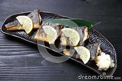 Studio shot of grilled atka mackerel with lemon on dark background Stock Photo