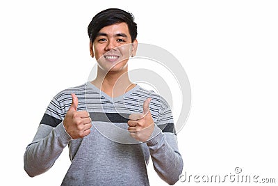 Studio shot of happy Asian man smiling and giving thumbs up Stock Photo