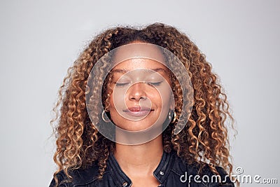 Studio Shot Of Happy Young Woman With Eyes Closed Daydreaming Stock Photo