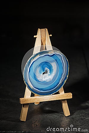 Blue agate slices on a miniature easel with copy space Stock Photo